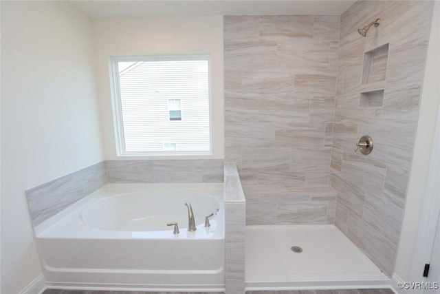 full bathroom with tiled shower and a garden tub