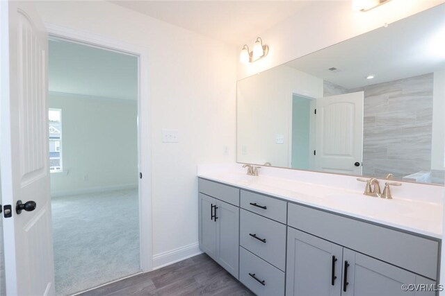 bathroom with hardwood / wood-style floors and dual bowl vanity