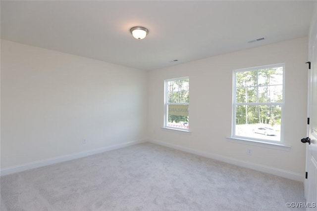 spare room with light carpet, baseboards, and visible vents