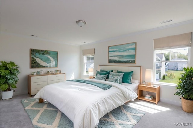 bedroom with baseboards, visible vents, crown molding, and light colored carpet