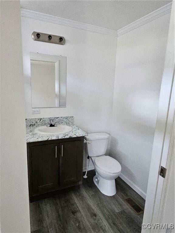 710 Wesley St, Petersburg, VA 23803 - bathroom with vanity, crown molding, toilet, visible vents, and wood finished floors