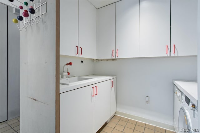 washroom featuring sink, cabinets, light tile floors, and washer / clothes dryer