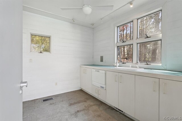 interior space featuring sink, ceiling fan, and white cabinetry