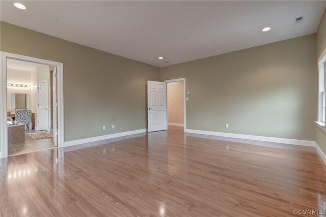 unfurnished bedroom featuring light hardwood / wood-style floors and connected bathroom