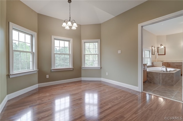 interior space featuring an inviting chandelier, lofted ceiling, and light wood-type flooring