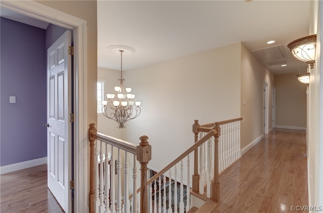 hall featuring light hardwood / wood-style floors and an inviting chandelier