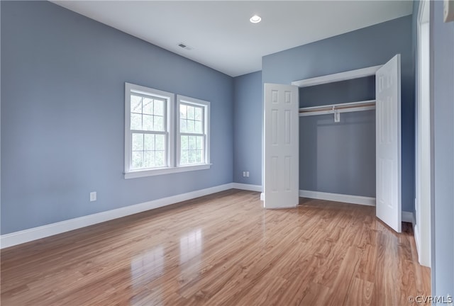 unfurnished bedroom with light hardwood / wood-style flooring and a closet