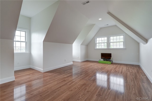 bonus room with hardwood / wood-style flooring, vaulted ceiling, and a wealth of natural light