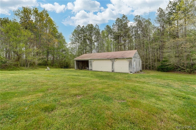 view of yard with a garage and an outbuilding