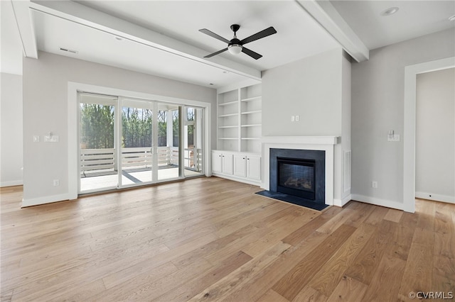 unfurnished living room with beamed ceiling, built in shelves, light wood-type flooring, and ceiling fan