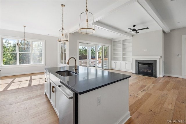 kitchen featuring light hardwood / wood-style floors, dishwasher, an island with sink, beam ceiling, and sink