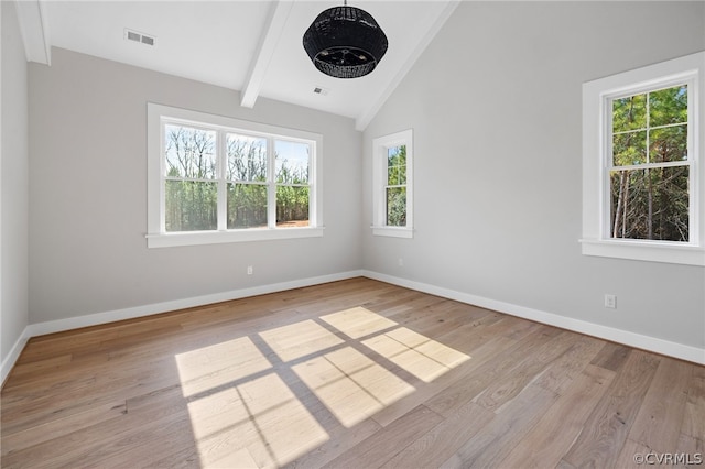 spare room featuring beamed ceiling, high vaulted ceiling, light hardwood / wood-style flooring, and a wealth of natural light