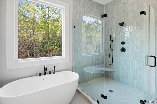 bathroom with a wealth of natural light and independent shower and bath