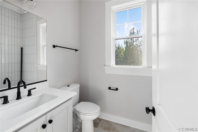 bathroom with vanity with extensive cabinet space, tile flooring, and toilet