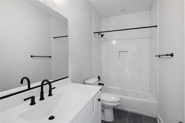 full bathroom with tile floors, vanity, toilet, and tiled shower / bath combo