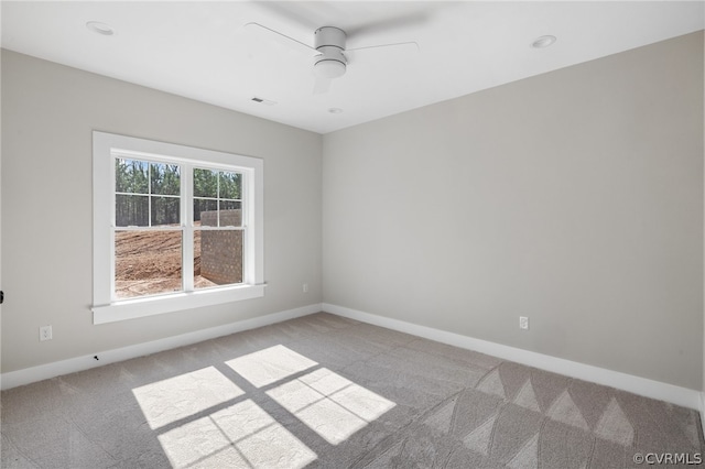 carpeted spare room with ceiling fan