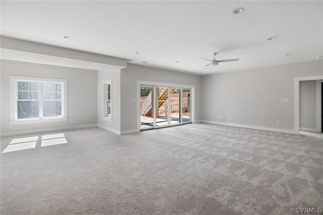 spare room featuring plenty of natural light and light colored carpet