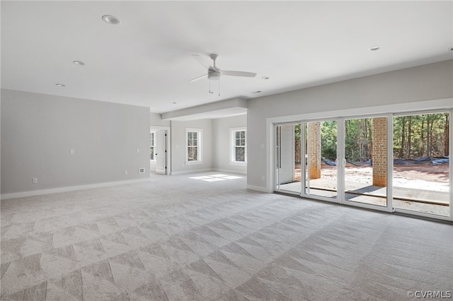 carpeted spare room with plenty of natural light and ceiling fan