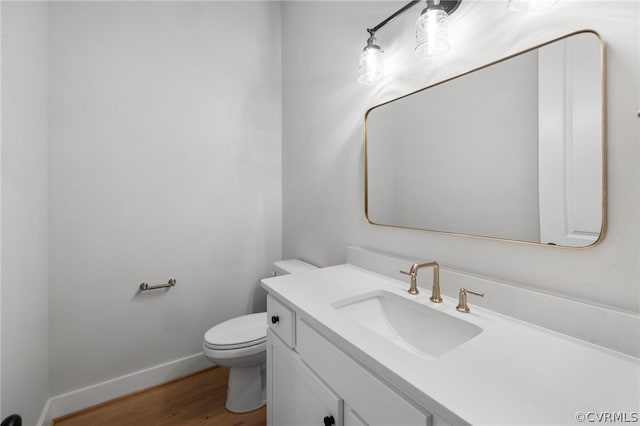 bathroom featuring wood-type flooring, vanity, and toilet