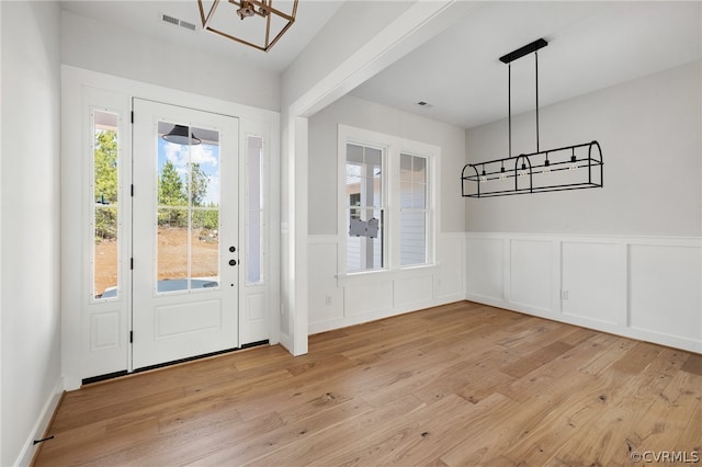 foyer entrance featuring light hardwood / wood-style floors and an inviting chandelier