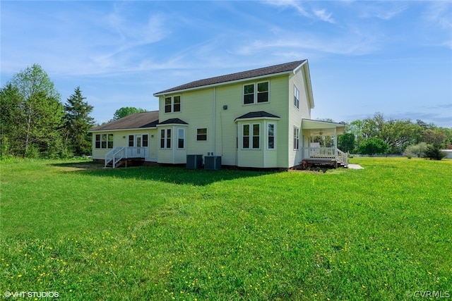 rear view of house with a yard and central air condition unit