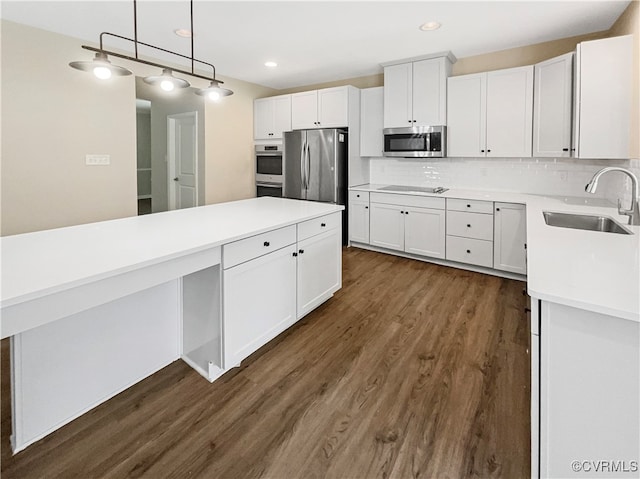 kitchen featuring white cabinets, appliances with stainless steel finishes, dark wood-type flooring, and sink