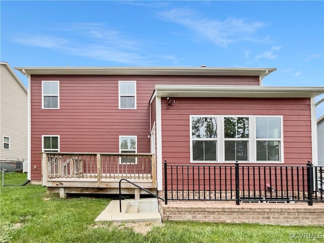 rear view of house featuring a lawn and a deck