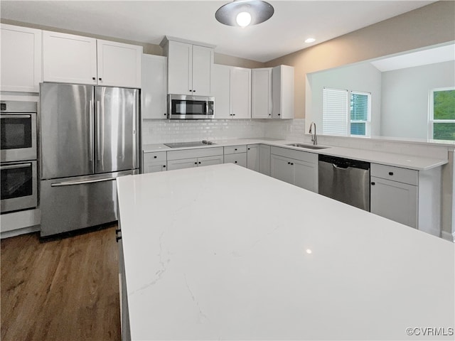 kitchen with appliances with stainless steel finishes, sink, dark hardwood / wood-style floors, and white cabinets