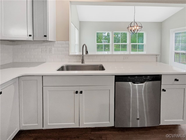 kitchen with white cabinetry, pendant lighting, an inviting chandelier, stainless steel dishwasher, and sink