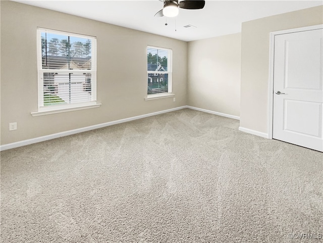 spare room featuring light carpet and ceiling fan