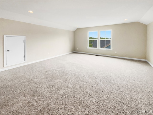 carpeted empty room featuring lofted ceiling