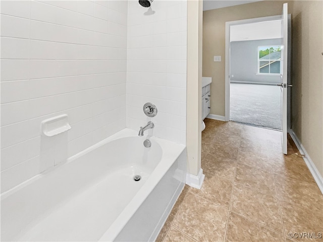 bathroom with tile patterned floors, tiled shower / bath, and vanity