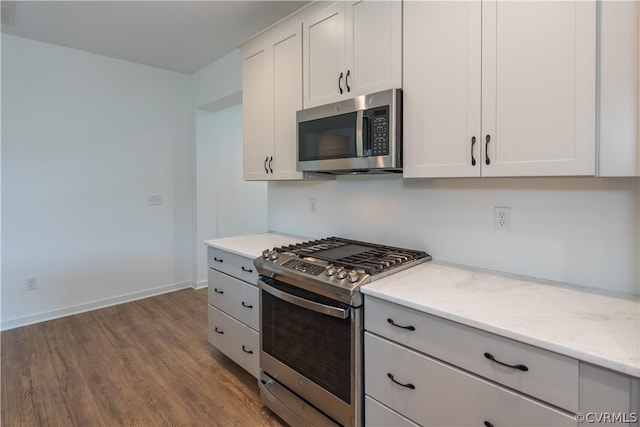 kitchen featuring light hardwood / wood-style floors, light stone countertops, stainless steel appliances, and white cabinetry