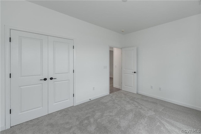 unfurnished bedroom with a closet and light carpet