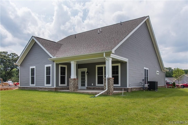 back of property featuring central AC unit and a lawn