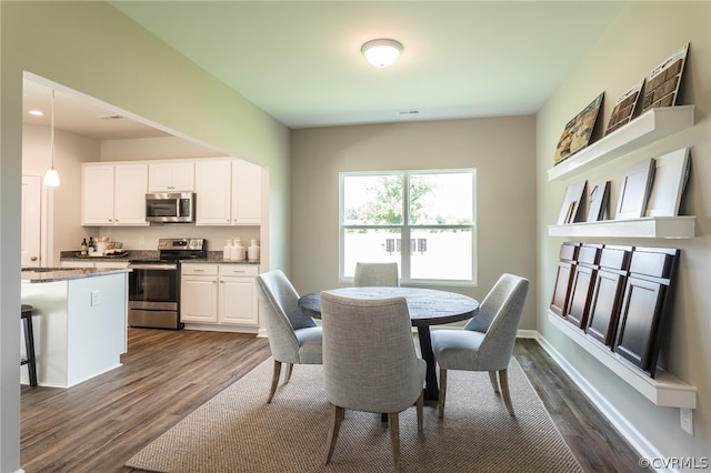 dining space with dark wood-type flooring