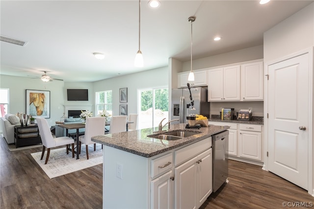 kitchen with white cabinetry, dark wood-type flooring, a kitchen island with sink, stainless steel appliances, and sink