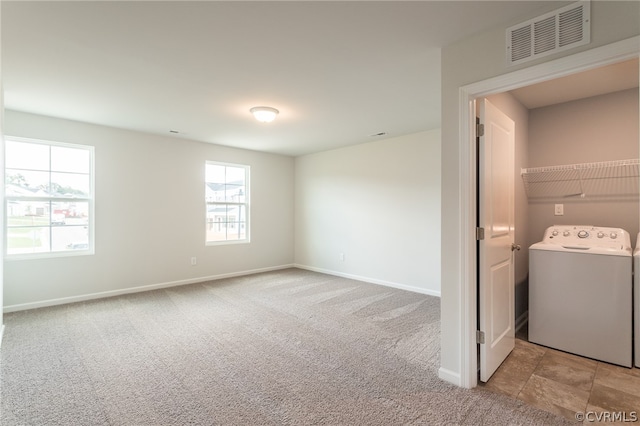 carpeted spare room featuring washer / clothes dryer