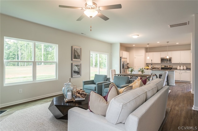 living room with ceiling fan, dark hardwood / wood-style flooring, and a healthy amount of sunlight