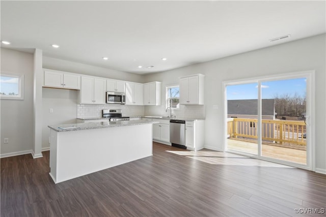 229 Bellevue Cir, King William, VA 23009 - kitchen featuring appliances with stainless steel finishes, a sink, decorative backsplash, white cabinets, and dark wood-type flooring