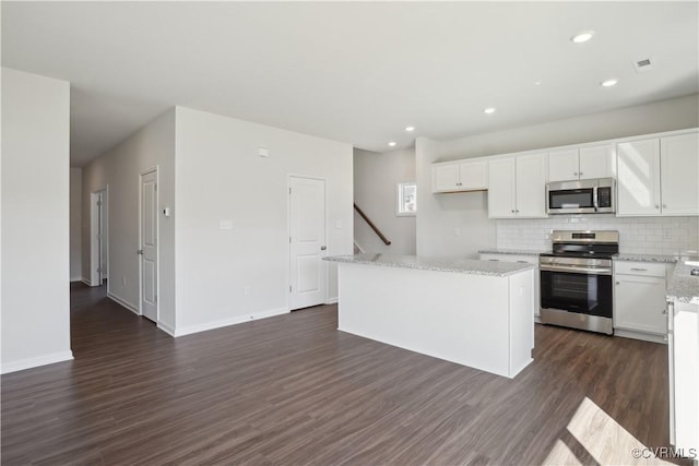 229 Bellevue Cir, King William, VA 23009 - kitchen with stainless steel appliances, dark wood-style floors, backsplash, white cabinetry, and a kitchen island
