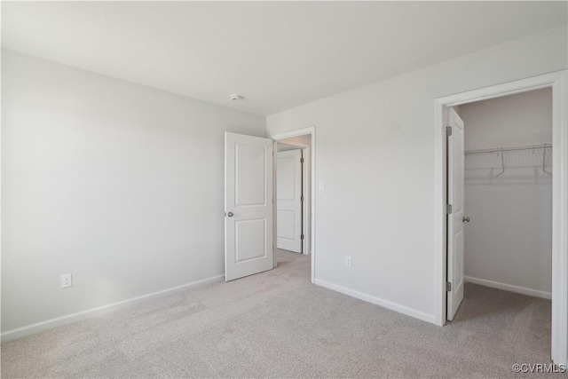 229 Bellevue Cir, King William, VA 23009 - unfurnished bedroom featuring light colored carpet, a walk in closet, baseboards, and a closet