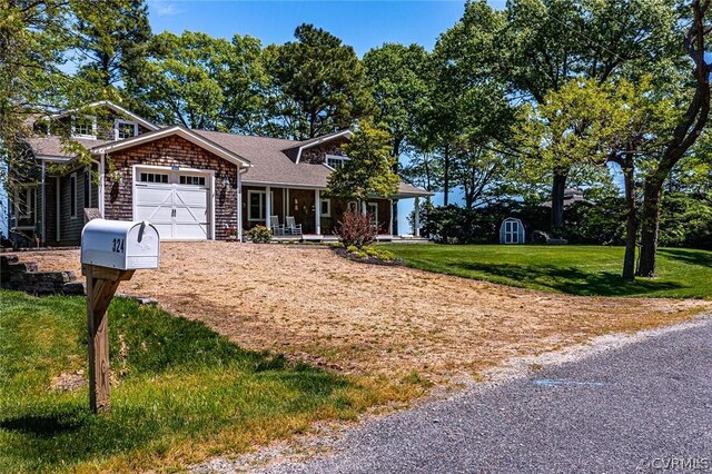 view of front of property featuring a garage, a front lawn, and covered porch