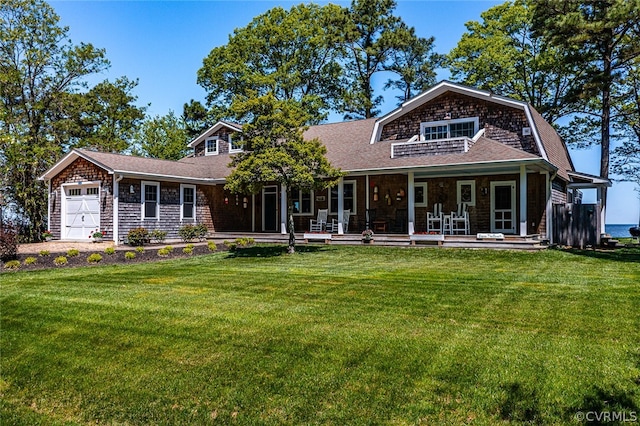 view of front facade featuring covered porch, a front yard, and a garage