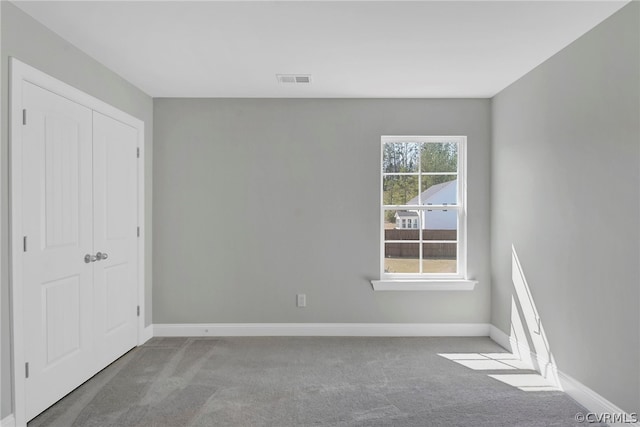 unfurnished bedroom featuring a closet and light colored carpet