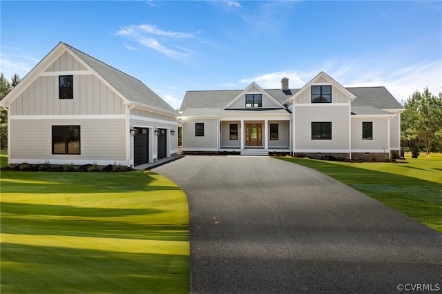 modern farmhouse with a front yard and a garage