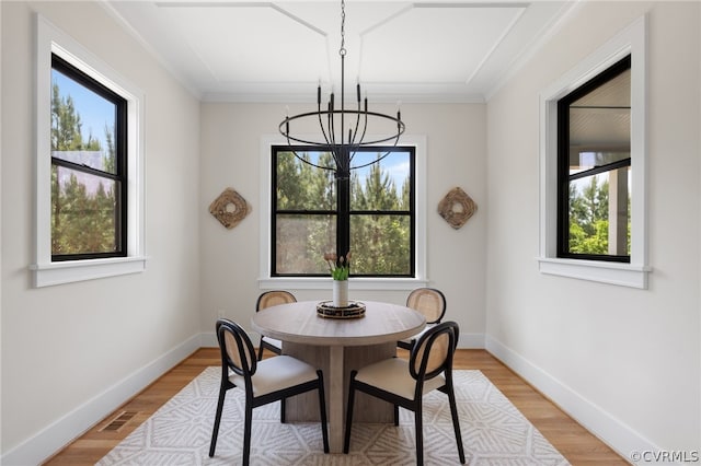 dining room with a chandelier, light hardwood / wood-style floors, and ornamental molding