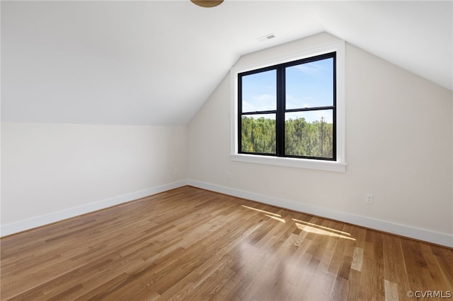 bonus room with vaulted ceiling and wood-type flooring