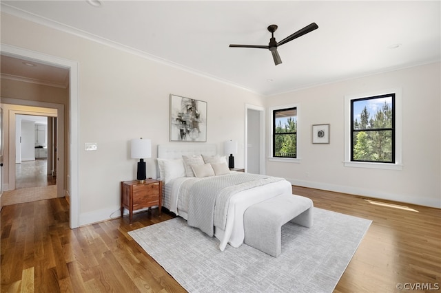 bedroom featuring wood-type flooring, ceiling fan, and crown molding