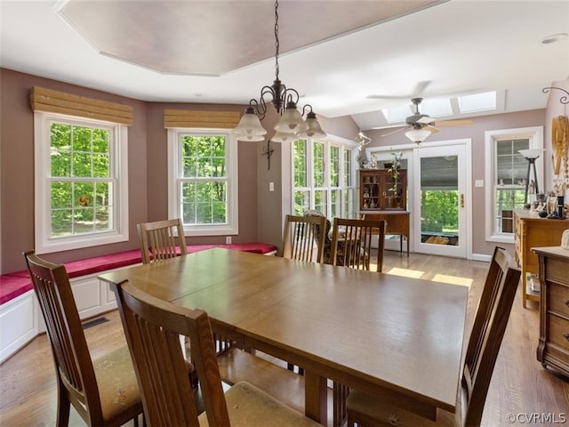 dining room with a chandelier, hardwood / wood-style flooring, and a skylight